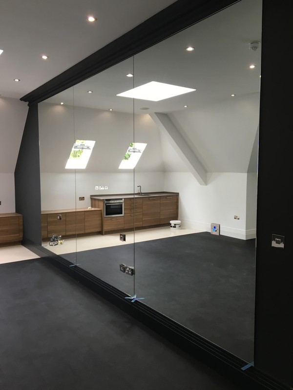 Frameless glass partition in loft conversion by Bethnal Green glaziers