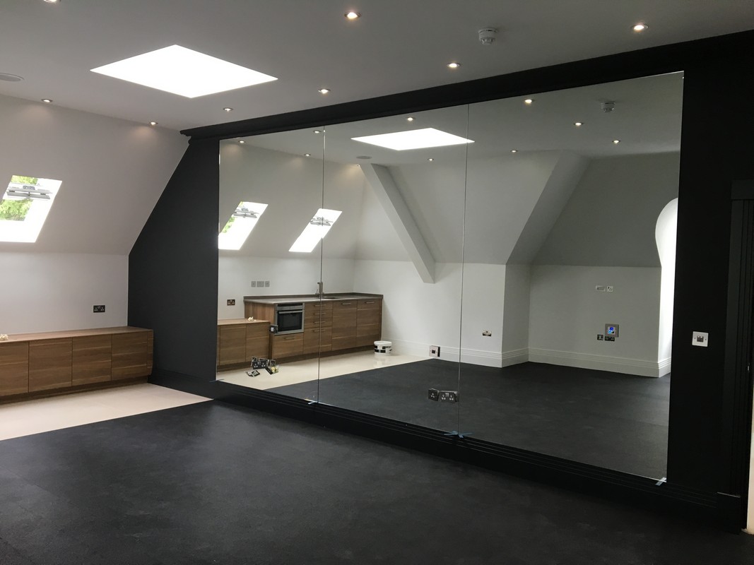 Frameless glass wall dividing loft conversion in Bethnal Green